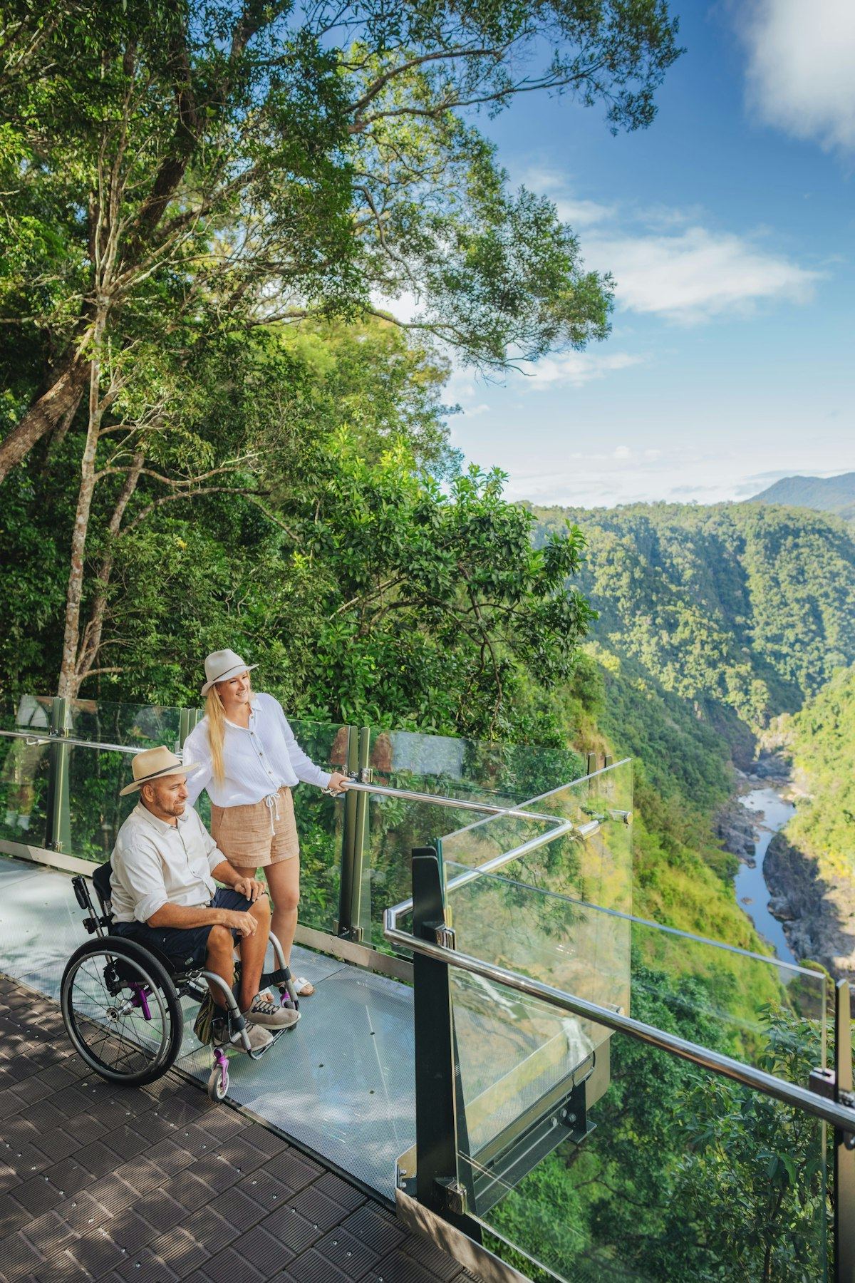 Man in a wheelchair with a friend at a rainforest lookout