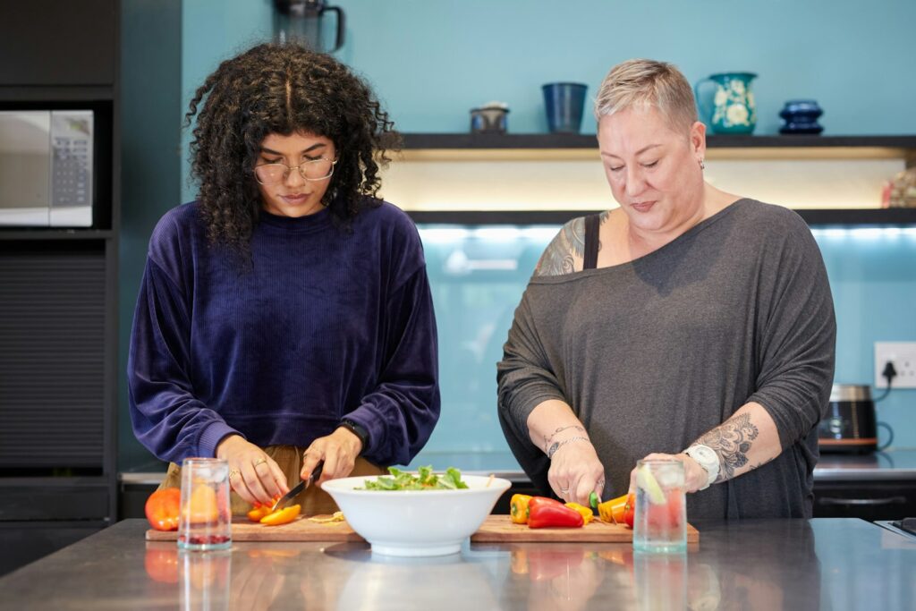 Two women preparing a meal together at a kitchen bench